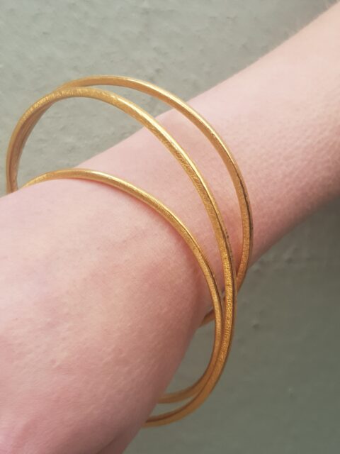 A double twisted sculptural bangle in 22ct yellow gold plate 