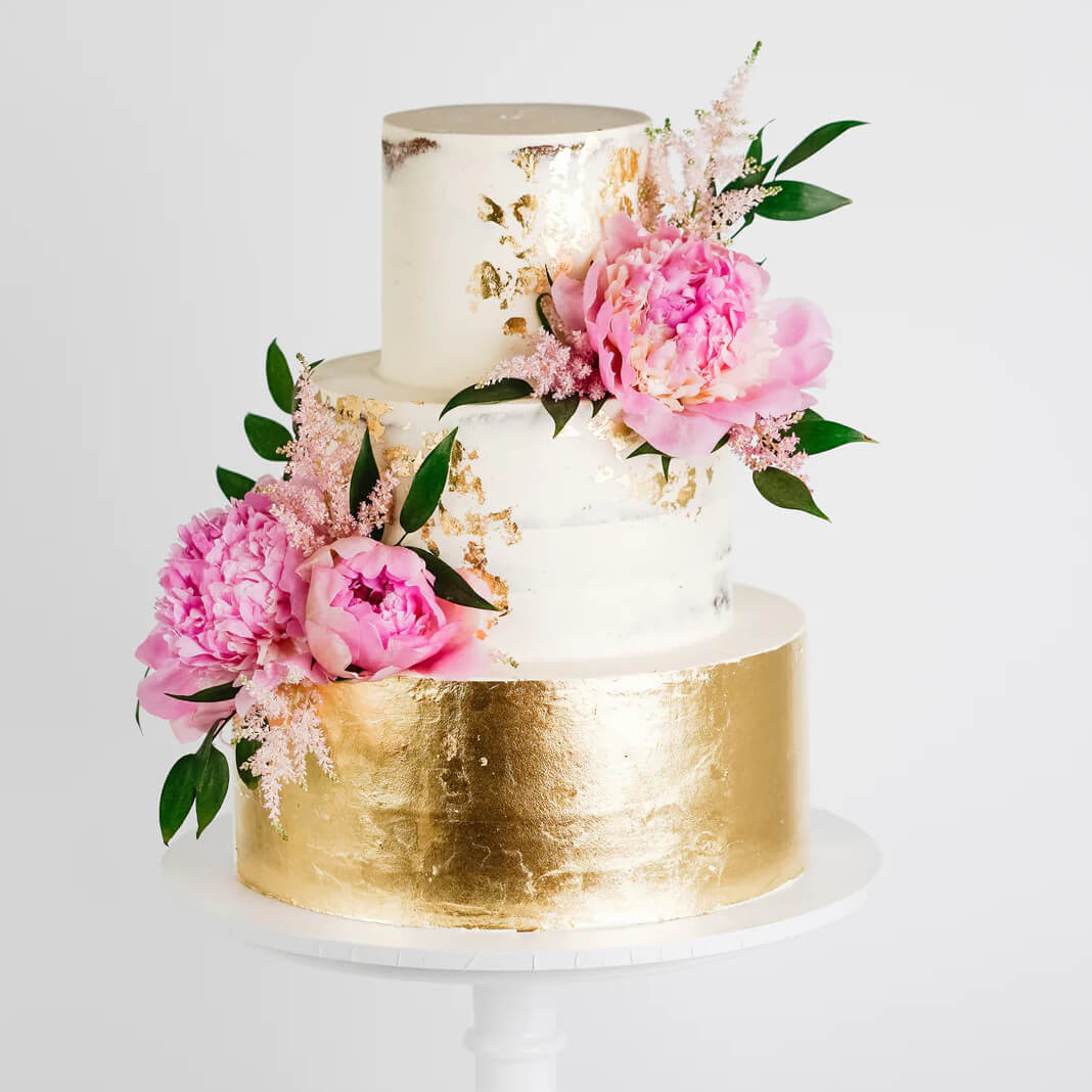 White 3 tier wedding cake with gold accents and pink flowers, made by Anna Couture in Clifton, Bristol